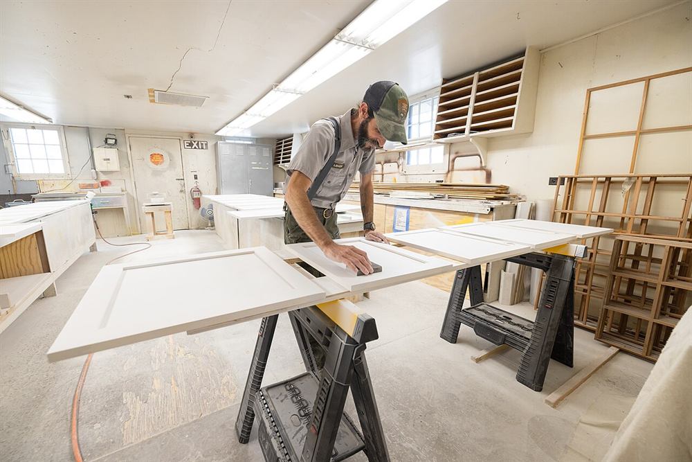 Tâmplar șlefuind uși de mobilier într-un atelier